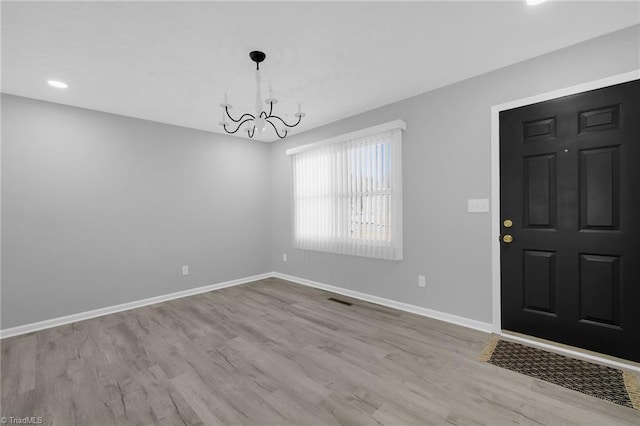 entryway featuring an inviting chandelier and light hardwood / wood-style flooring