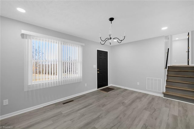 interior space featuring an inviting chandelier and light hardwood / wood-style floors