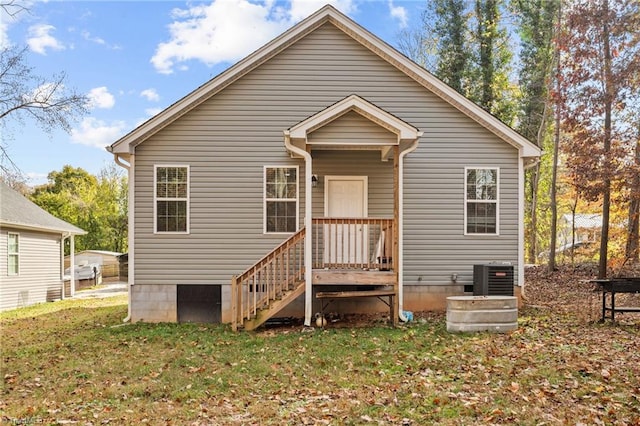 rear view of house featuring central AC unit and a lawn