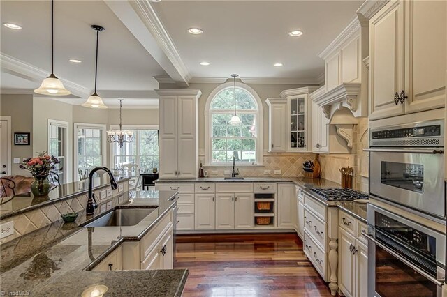 925 Salem Glen Ct, Clemmons, NC 27012 - kitchen with stainless steel gas stovetop, dark wood-type flooring, a chandelier, dark stone counters, and decorative light fixtures