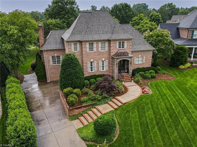 925 Salem Glen Ct, Clemmons, NC 27012 - colonial house with brick siding, a front lawn, a chimney, and a shingled roof