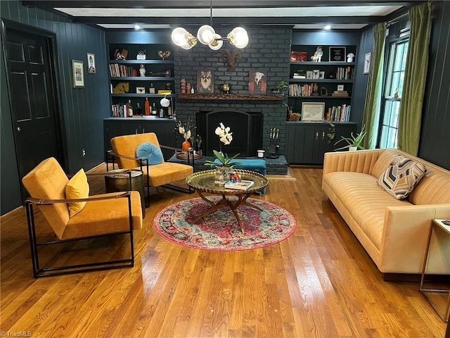590 Knob View Dr, Winston-Salem, NC 27104 - living area featuring built in shelves, wood finished floors, a fireplace, and a chandelier