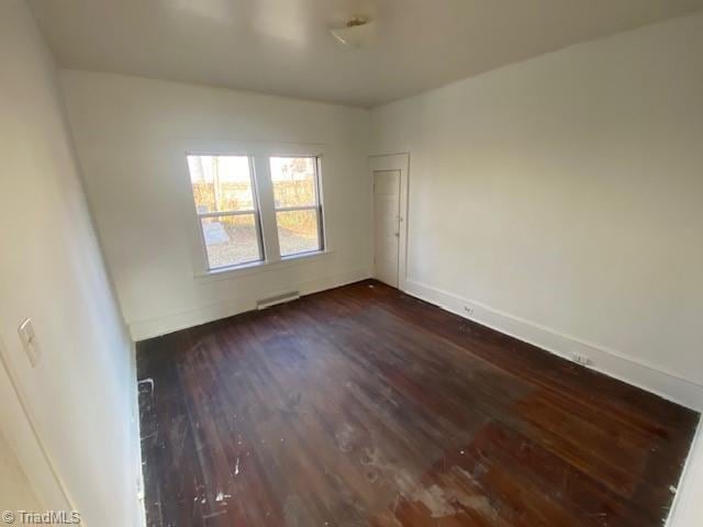 unfurnished room featuring dark wood-type flooring