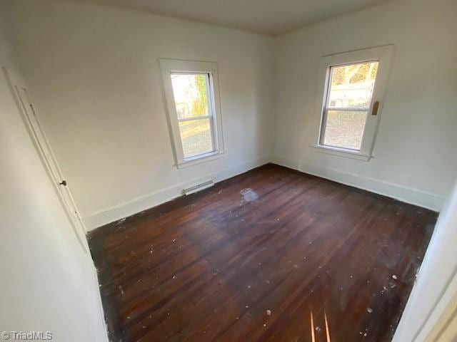 spare room featuring dark wood-type flooring