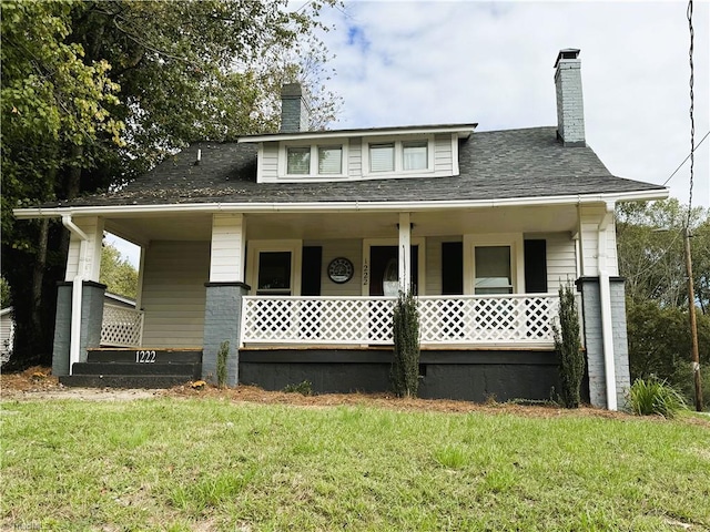 view of front facade featuring a front lawn and covered porch