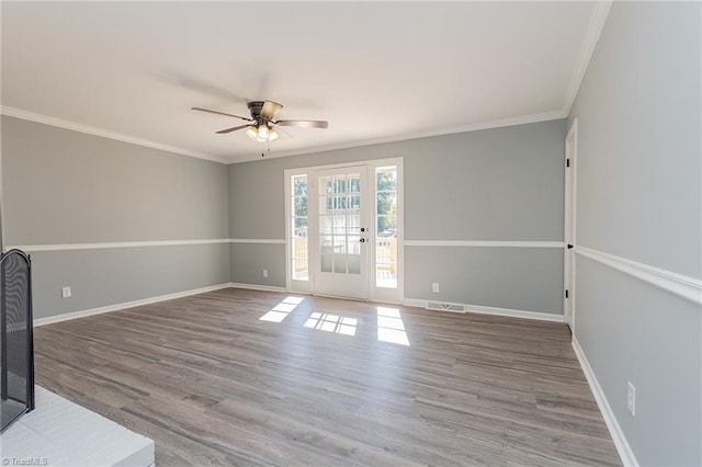 empty room featuring ceiling fan, hardwood / wood-style floors, and crown molding