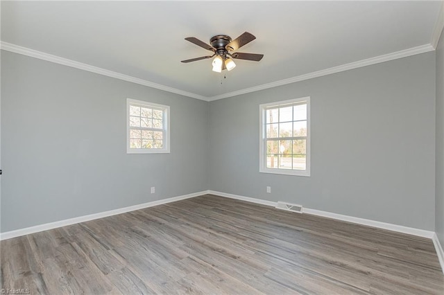 unfurnished room with a wealth of natural light, hardwood / wood-style floors, and crown molding