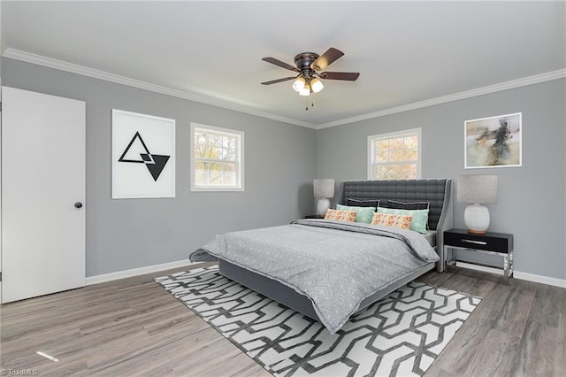 bedroom featuring hardwood / wood-style flooring, ceiling fan, and crown molding