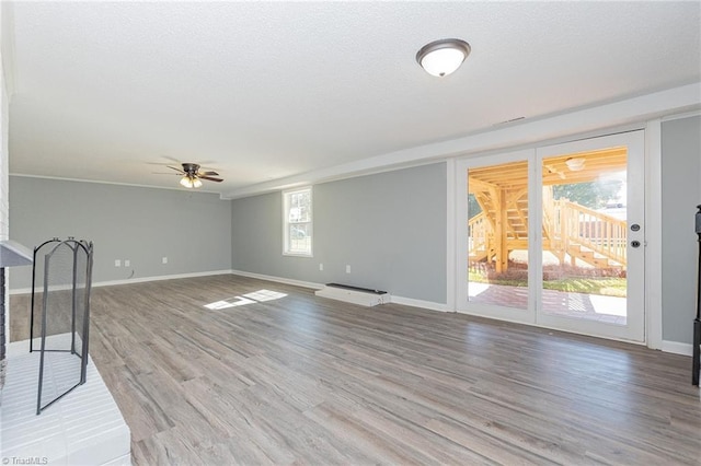 unfurnished living room with light hardwood / wood-style floors, a wealth of natural light, and ceiling fan