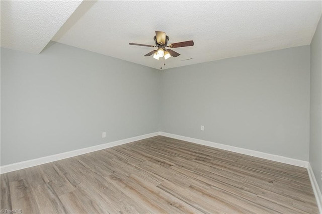 spare room featuring ceiling fan, a textured ceiling, and light wood-type flooring