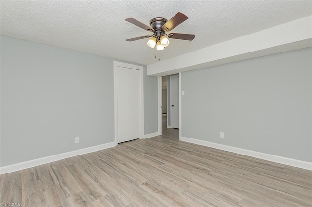 unfurnished room featuring ceiling fan, light hardwood / wood-style floors, and a textured ceiling