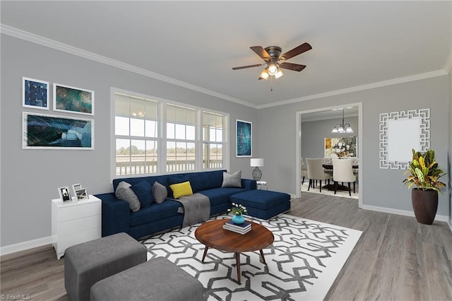 living room featuring ceiling fan with notable chandelier, wood-type flooring, and crown molding