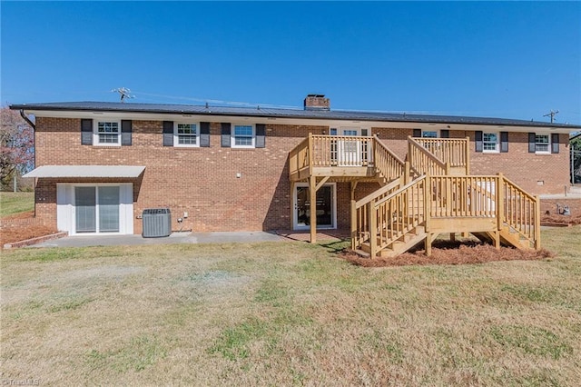 rear view of property featuring a lawn, cooling unit, and a wooden deck