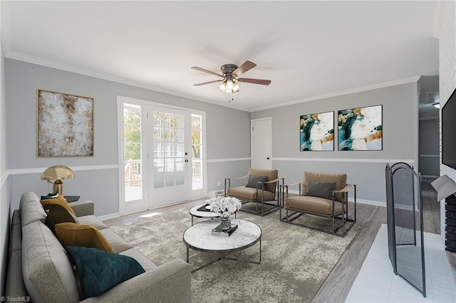 living room with ceiling fan, ornamental molding, and light wood-type flooring