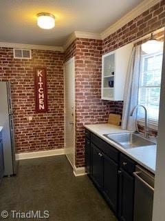 2920 Ramsgate Ct, Winston-Salem, NC 27106 - kitchen featuring crown molding, light countertops, dishwasher, brick wall, and freestanding refrigerator