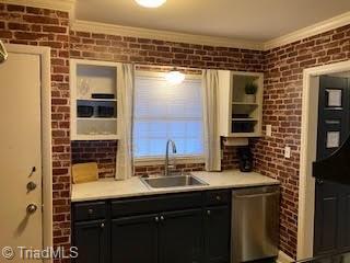 2920 Ramsgate Ct, Winston-Salem, NC 27106 - kitchen featuring stainless steel dishwasher, ornamental molding, light countertops, brick wall, and dark cabinetry