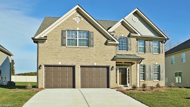 view of front facade featuring a garage, central air condition unit, and a front yard