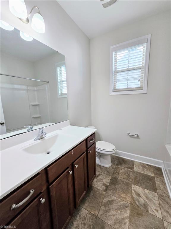 bathroom with a chandelier, vanity, and toilet