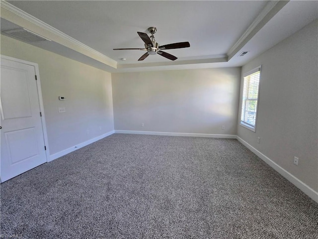 carpeted spare room with a tray ceiling, ceiling fan, and crown molding