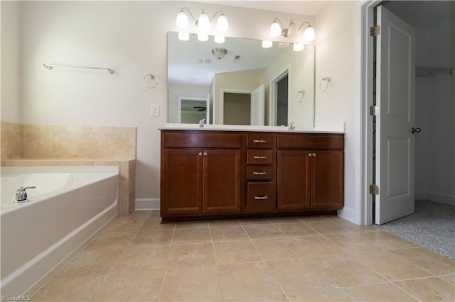 bathroom with tile patterned flooring, a washtub, and vanity