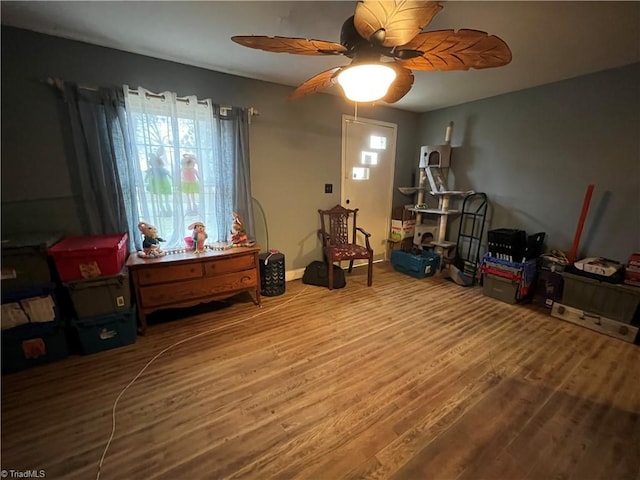 interior space with ceiling fan, baseboards, and wood finished floors