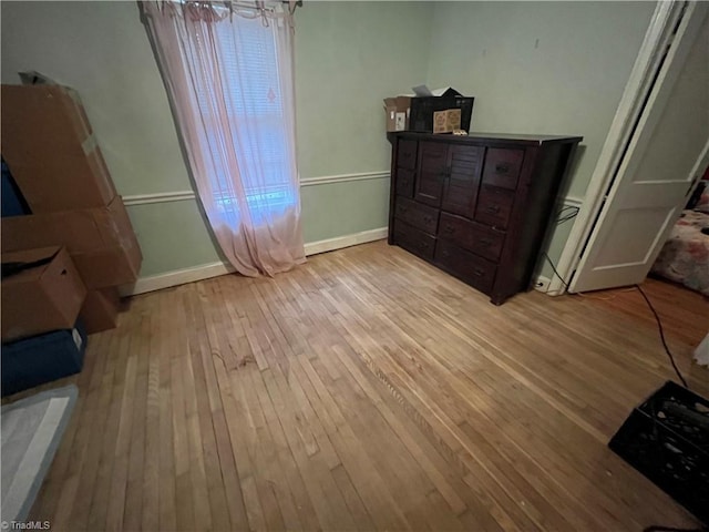 bedroom with baseboards and light wood finished floors