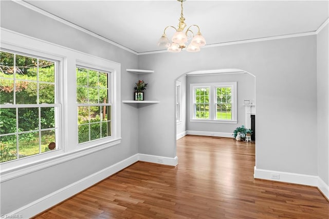 7090 Reynolda Rd, Pfafftown, NC 27040 - unfurnished dining area featuring a chandelier, arched walkways, wood finished floors, a fireplace, and ornamental molding