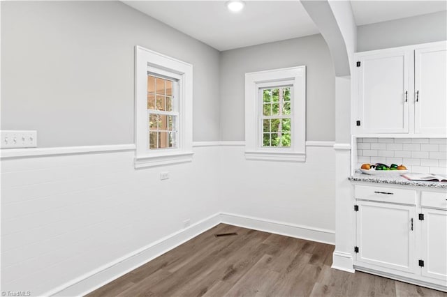 7090 Reynolda Rd, Pfafftown, NC 27040 - unfurnished dining area with a wainscoted wall, wood finished floors, arched walkways, and recessed lighting