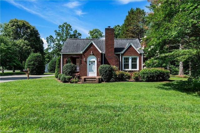7090 Reynolda Rd, Pfafftown, NC 27040 - tudor house with a front yard, a chimney, and brick siding