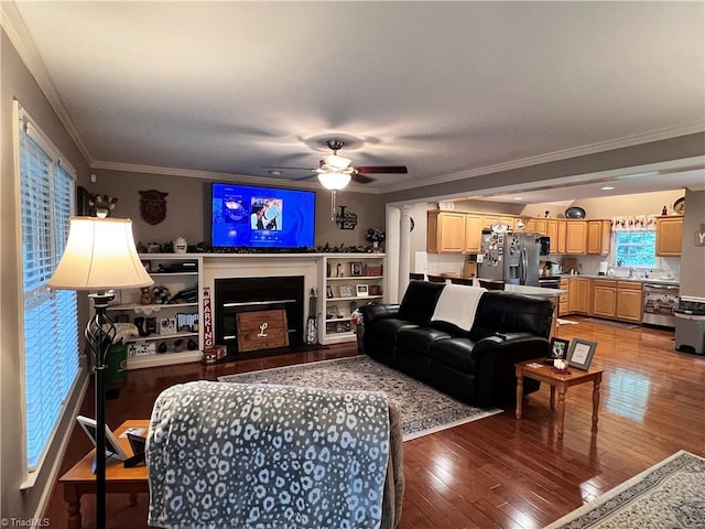 living room featuring ceiling fan, wood-type flooring, and ornamental molding