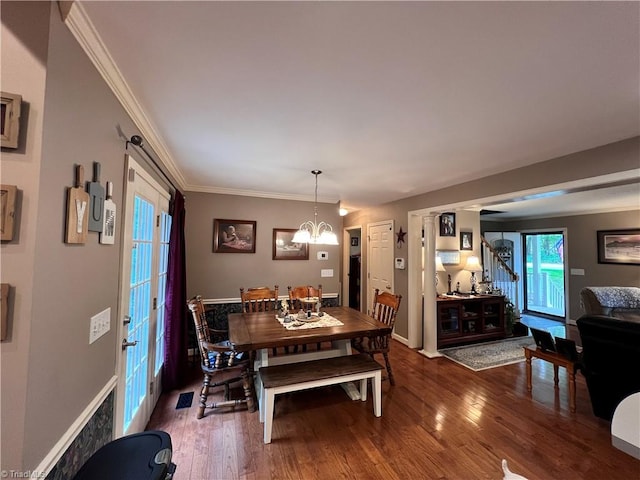 dining room with crown molding, a chandelier, and dark hardwood / wood-style flooring