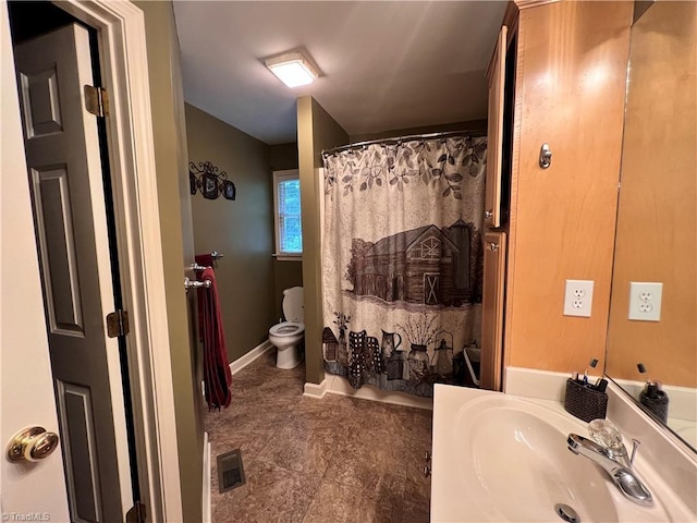 bathroom featuring a shower with shower curtain, toilet, and vanity