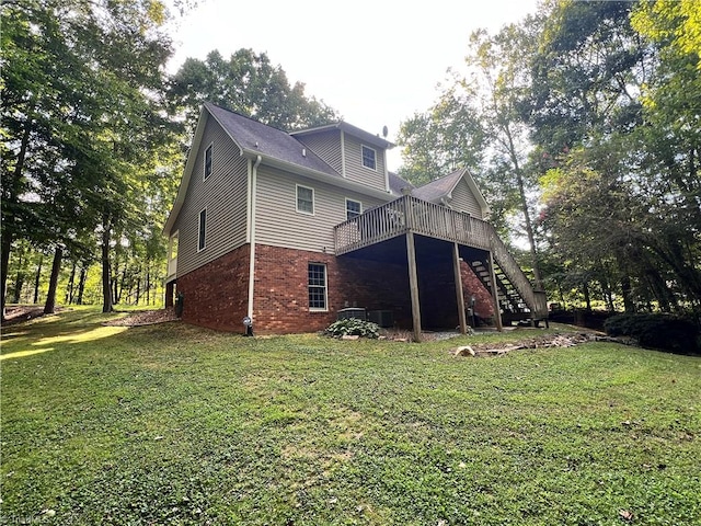 back of property with a yard, central AC unit, and a deck