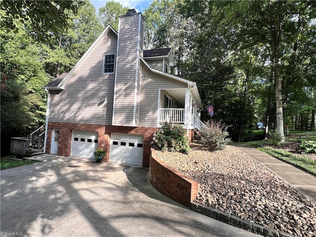 view of home's exterior with a garage and a porch