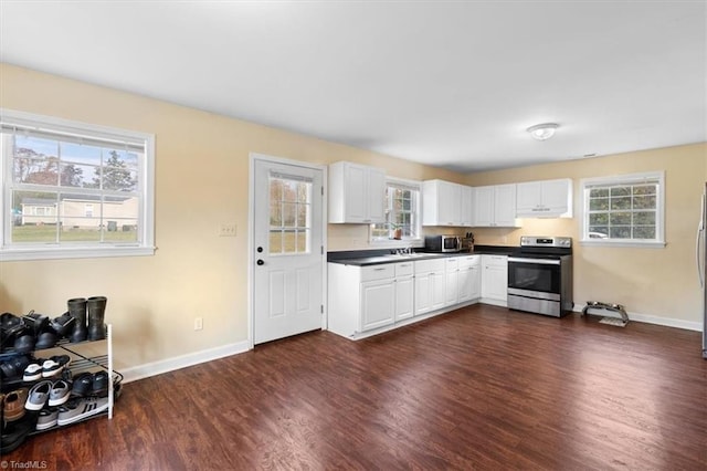 kitchen featuring dark countertops, baseboards, stainless steel appliances, and dark wood finished floors