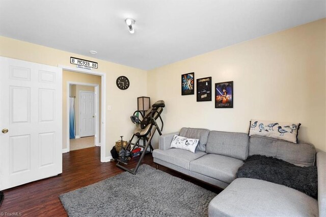 living area with baseboards and wood finished floors