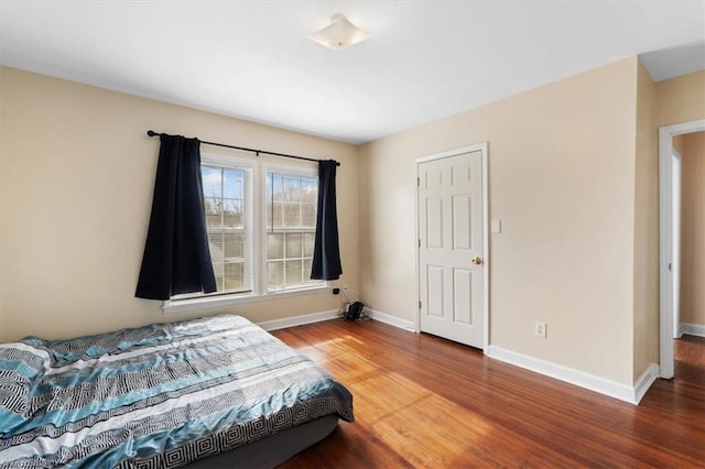 bedroom with baseboards and wood finished floors