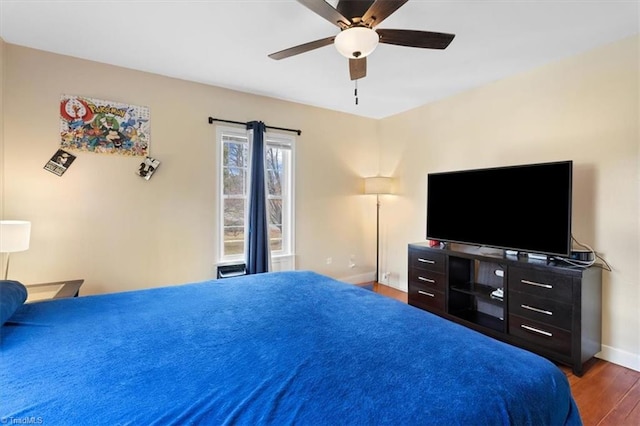 bedroom with ceiling fan, baseboards, and wood finished floors