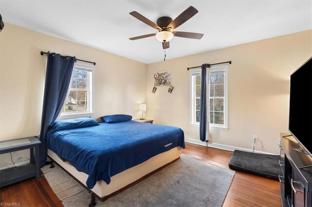 bedroom featuring ceiling fan, baseboards, and wood finished floors