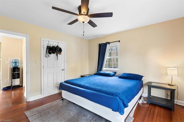 bedroom featuring a ceiling fan, baseboards, and wood finished floors