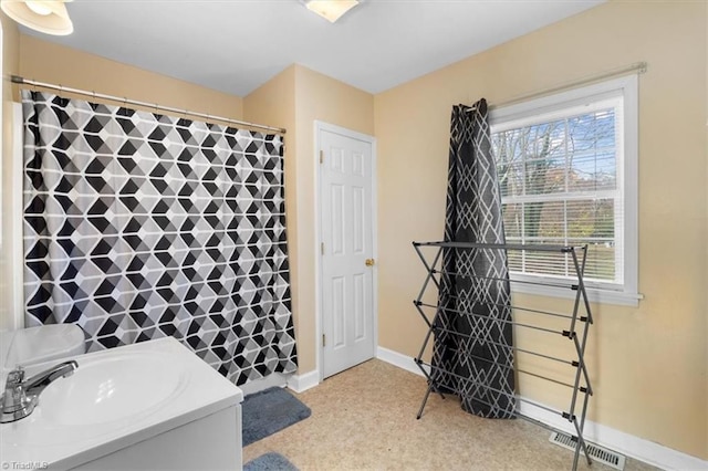 bathroom with a shower with curtain, baseboards, and visible vents