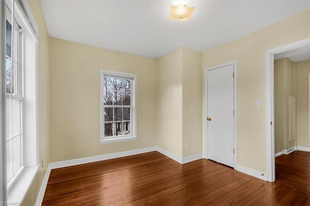 empty room featuring baseboards and hardwood / wood-style flooring