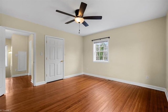 unfurnished bedroom with wood finished floors, a ceiling fan, and baseboards