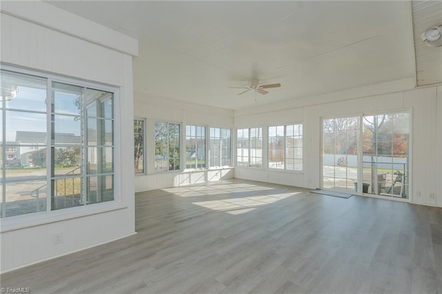 unfurnished sunroom featuring ceiling fan and a wealth of natural light