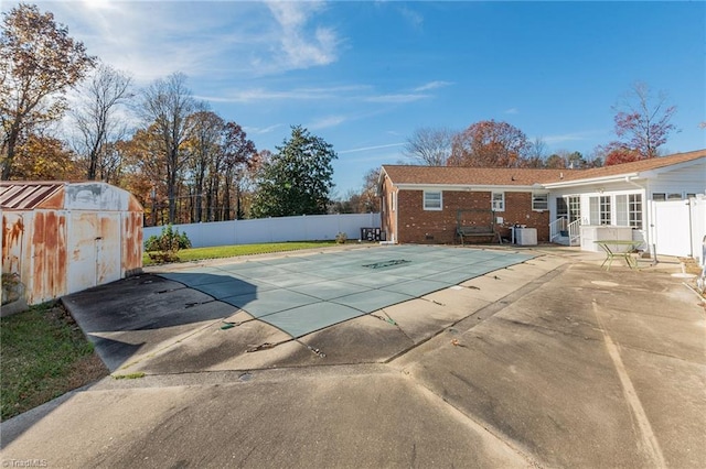 view of pool featuring a shed and a patio