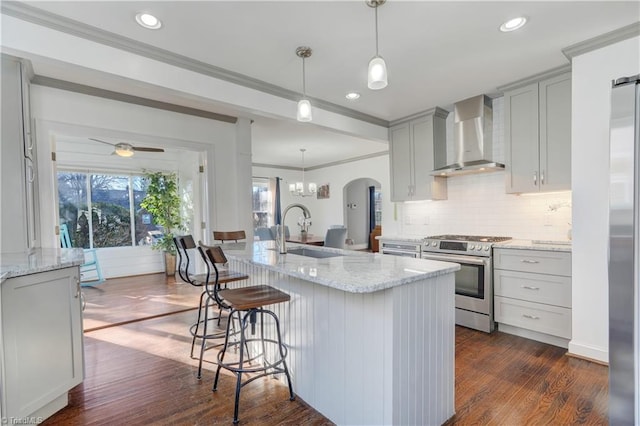 kitchen featuring light stone countertops, stainless steel range, dark wood-type flooring, sink, and wall chimney range hood