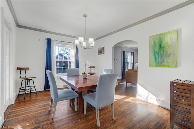 dining space with dark hardwood / wood-style flooring, an inviting chandelier, and ornamental molding