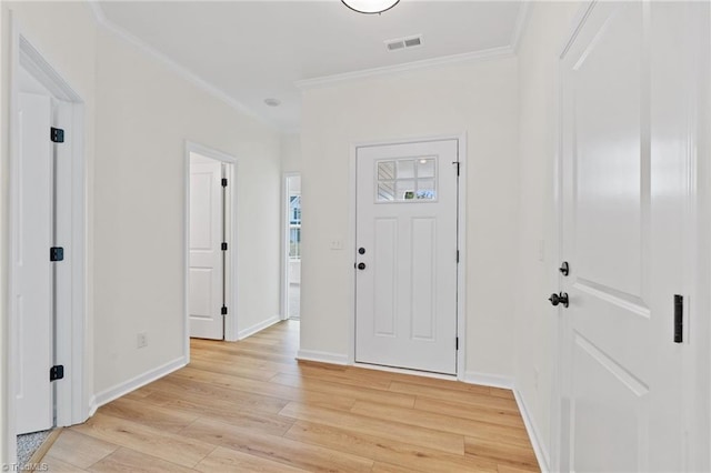 foyer entrance with ornamental molding and light hardwood / wood-style floors