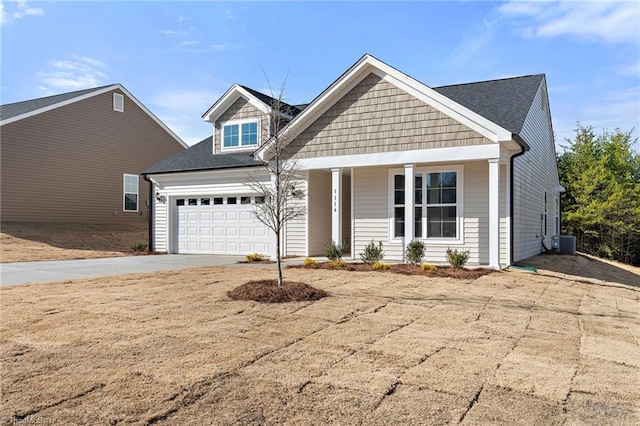 view of front of house featuring a garage, covered porch, and central air condition unit