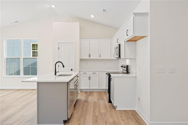 kitchen featuring white cabinetry, appliances with stainless steel finishes, sink, and an island with sink